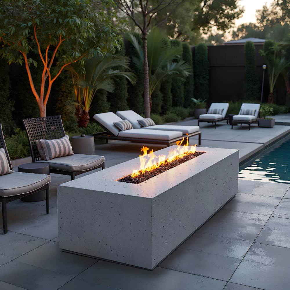 Light gray gas fire table with lit flames in rectangular burner pan and wide square base