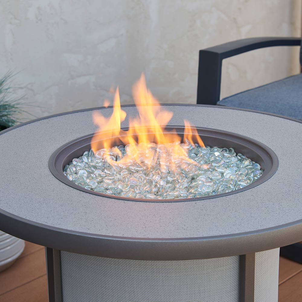 Gas fire table burner with flames above clear glass fire media