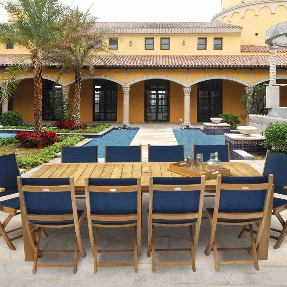Folding teak arm chairs with navy blue sling seat and backrest, set on patio.