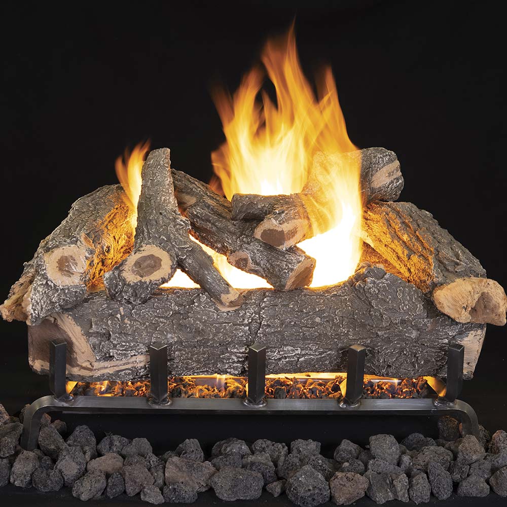Vented ceramic gas log set with smoky weathered logs and glowing flames over black ember bed