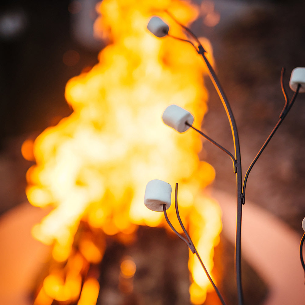 Marshmallow roasting stick with white cube holders, shown near a large fire flame