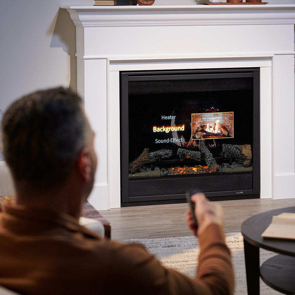 Electric fireplace remote in hand near an electric fireplace insert