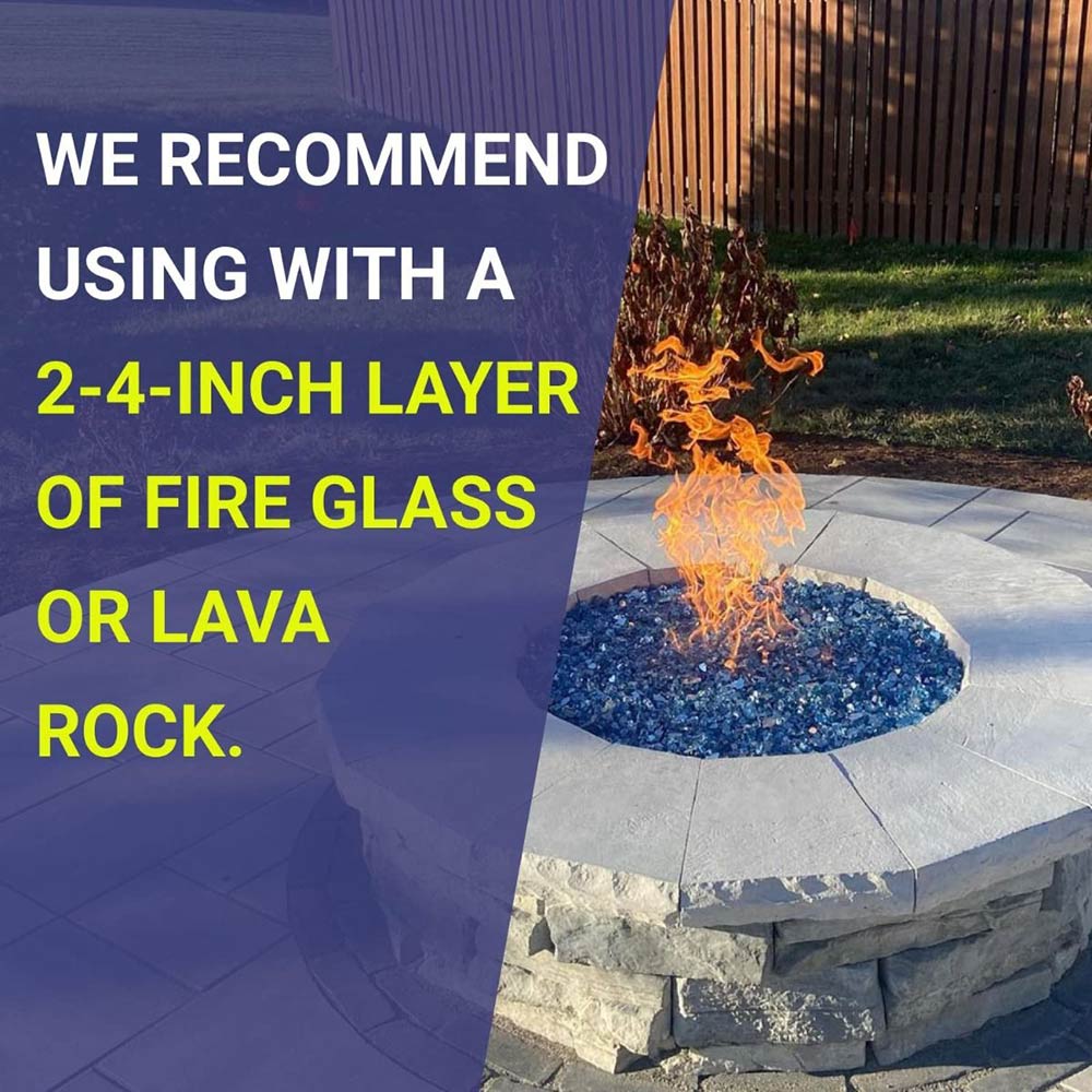 Round fire pit burner with blue fire glass and flames on a stone surround