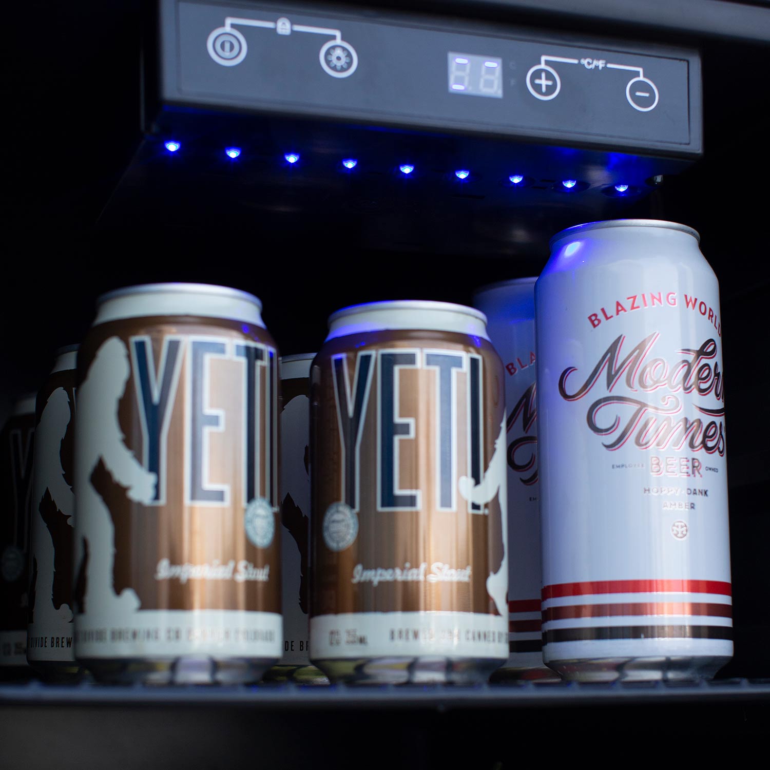 Refrigerator shelf with can drinks under blue LED light panel