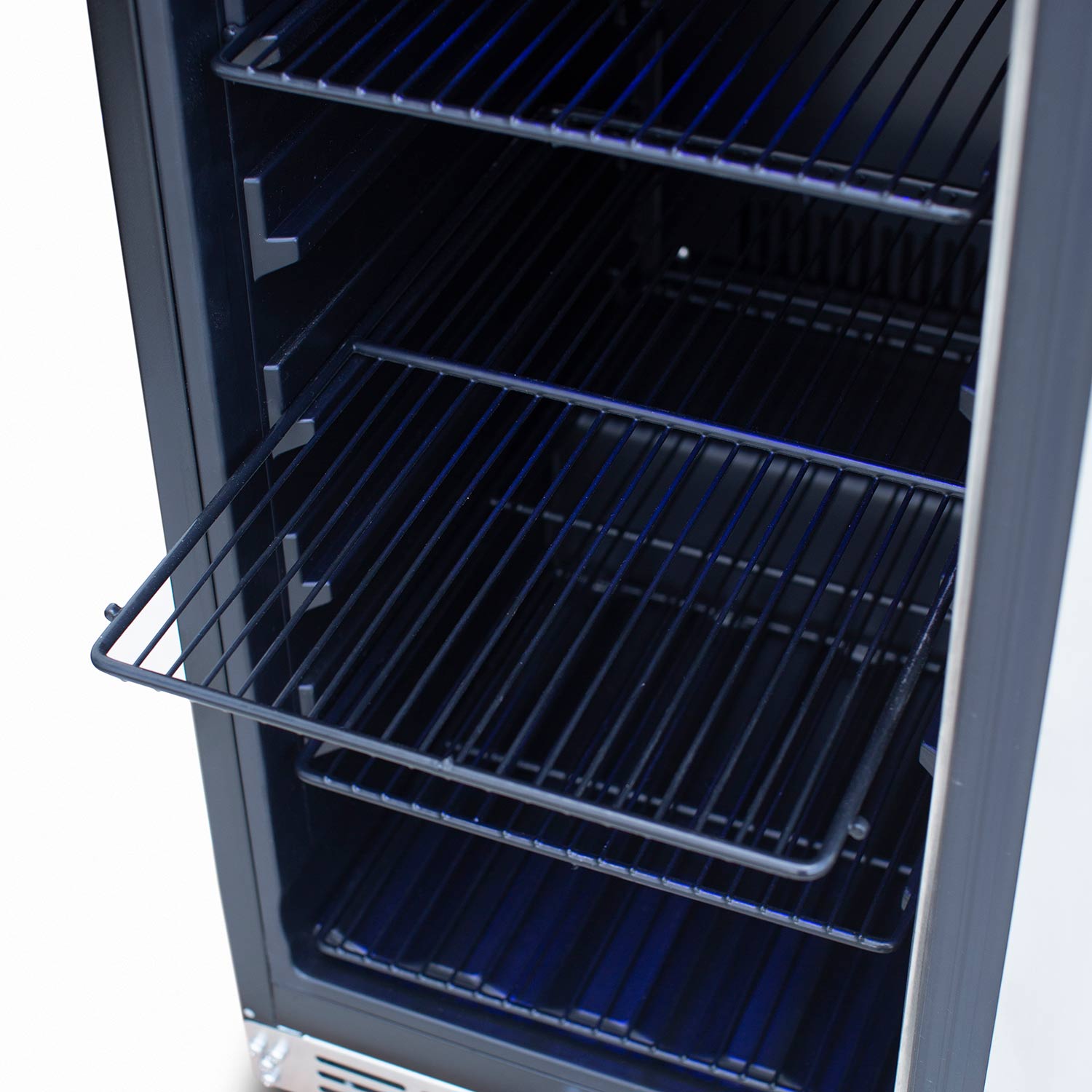 Interior view of refrigerator with wire shelves and back cooling coils