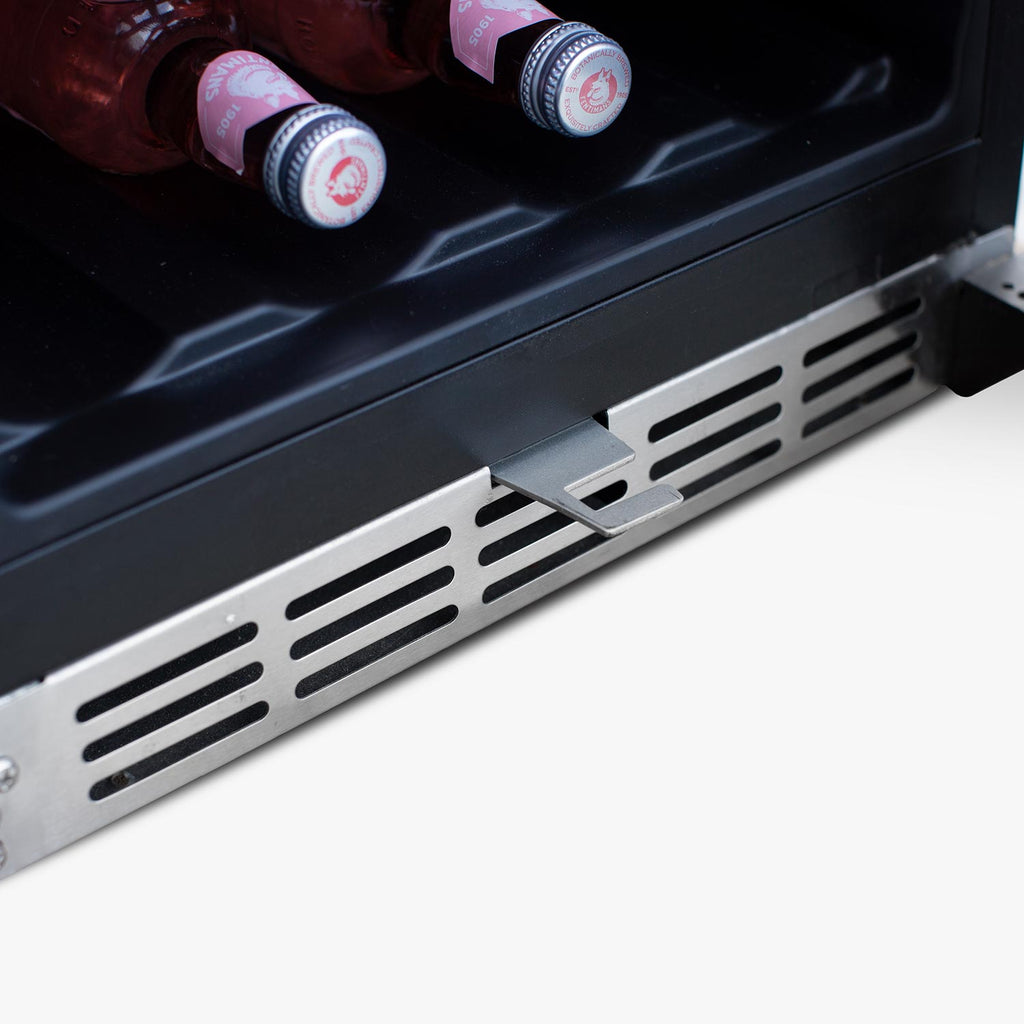 Bottom interior shelf of refrigerator with front vented grille and bottled drinks