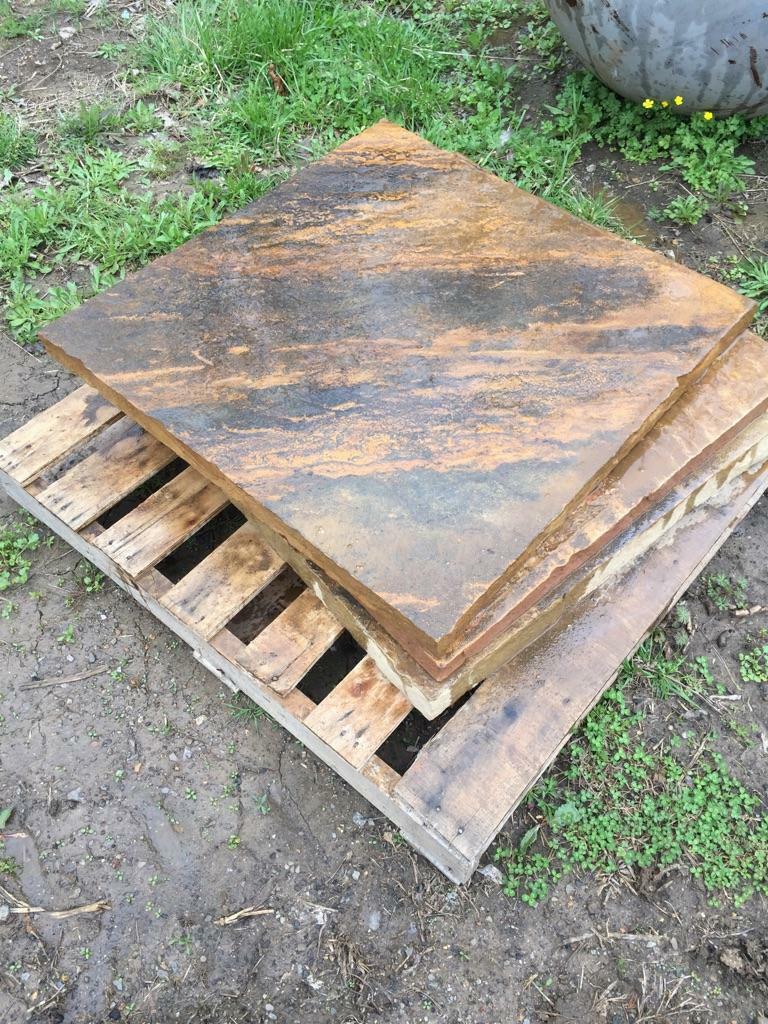 Limestone fire pit base slab on wooden pallet, tan and blue-gray mottled surface