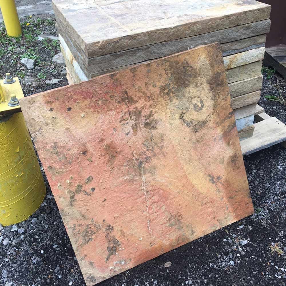 Limestone fire pit base slab, reddish-brown and gray speckled stone surface