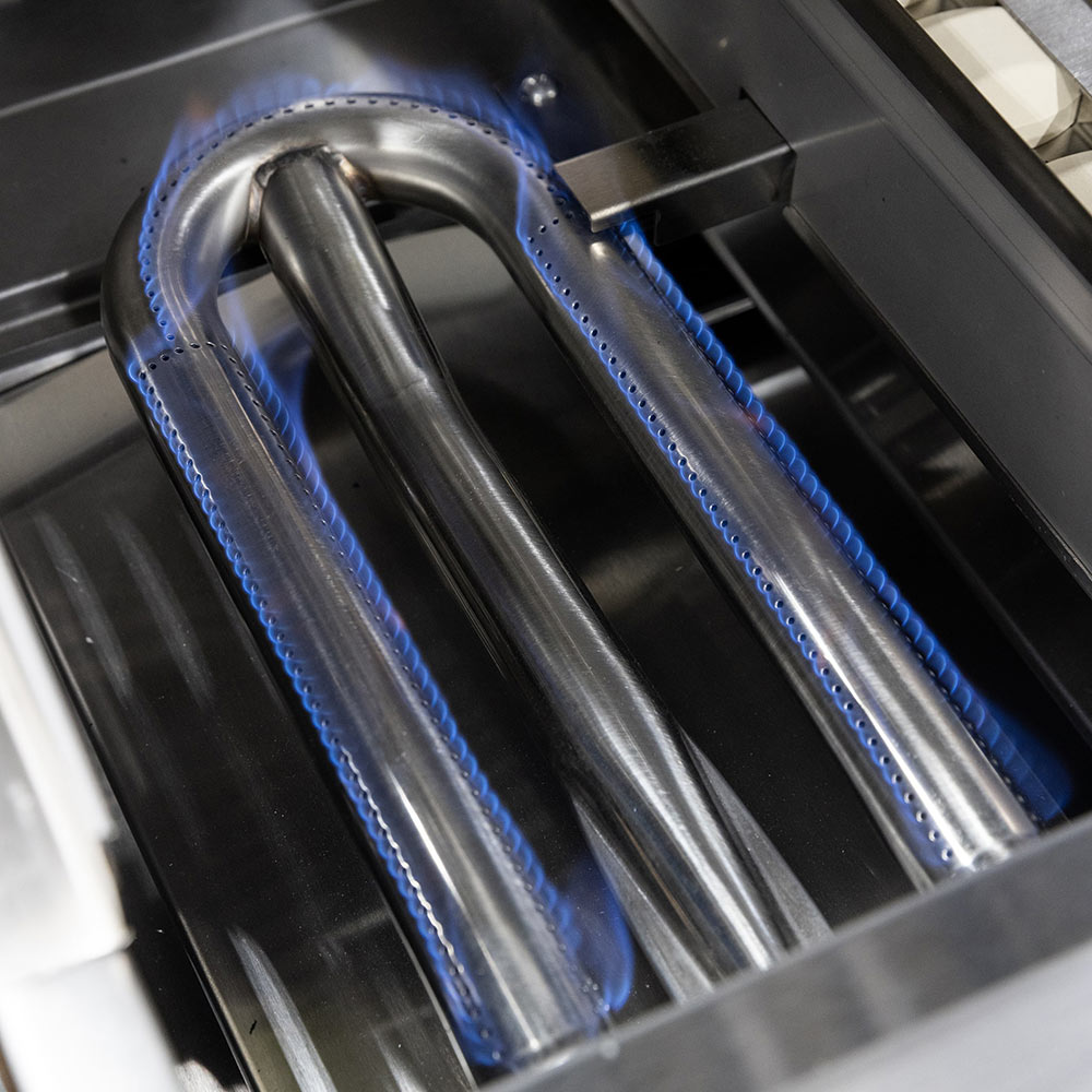 Gas grill burners with blue flame ports over stainless firebox