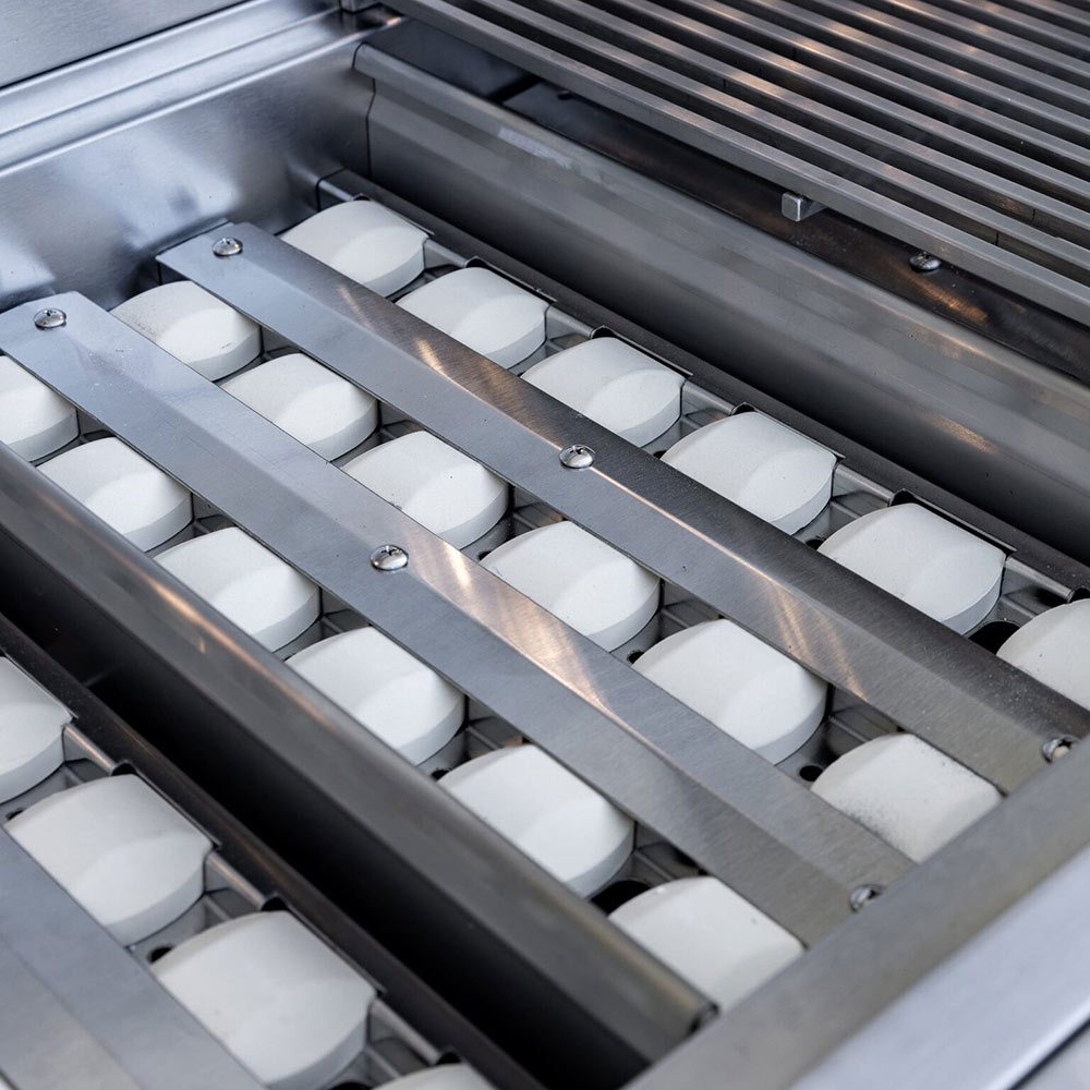 Gas grill heat plates and burners beneath cooking grates inside firebox