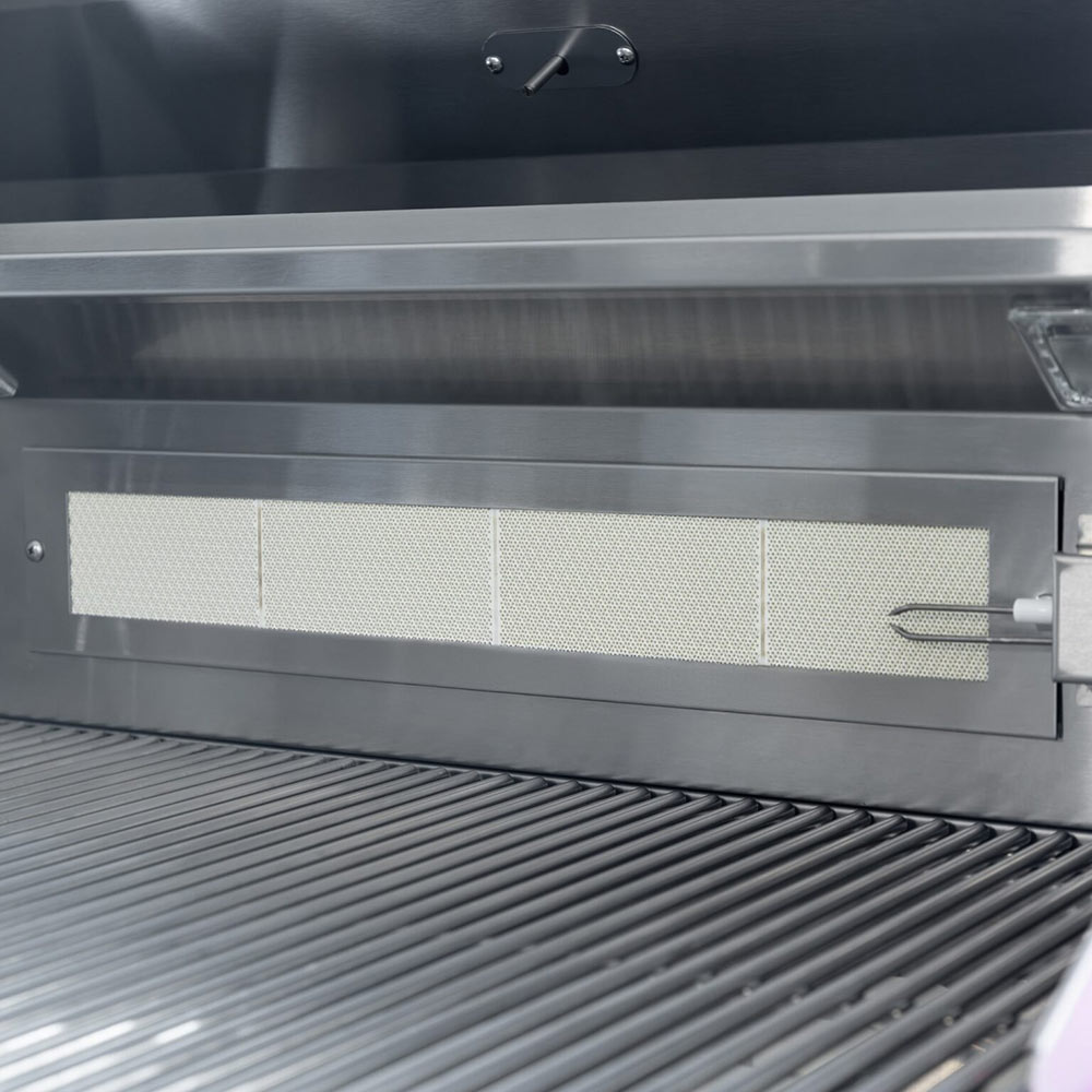 Gas grill heat shield with perforated panel and front cooking grates.