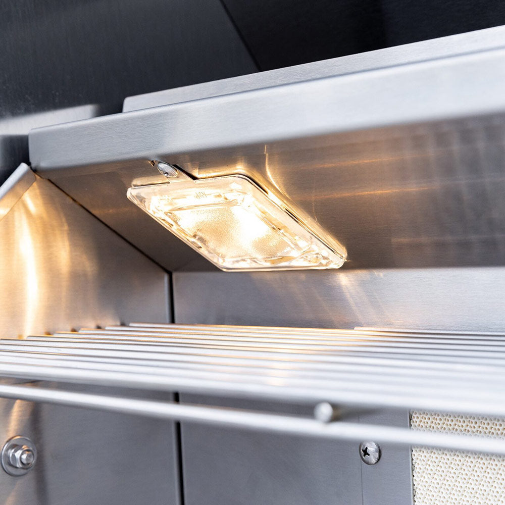 Gas grill interior light over the cooking area inside the hood.