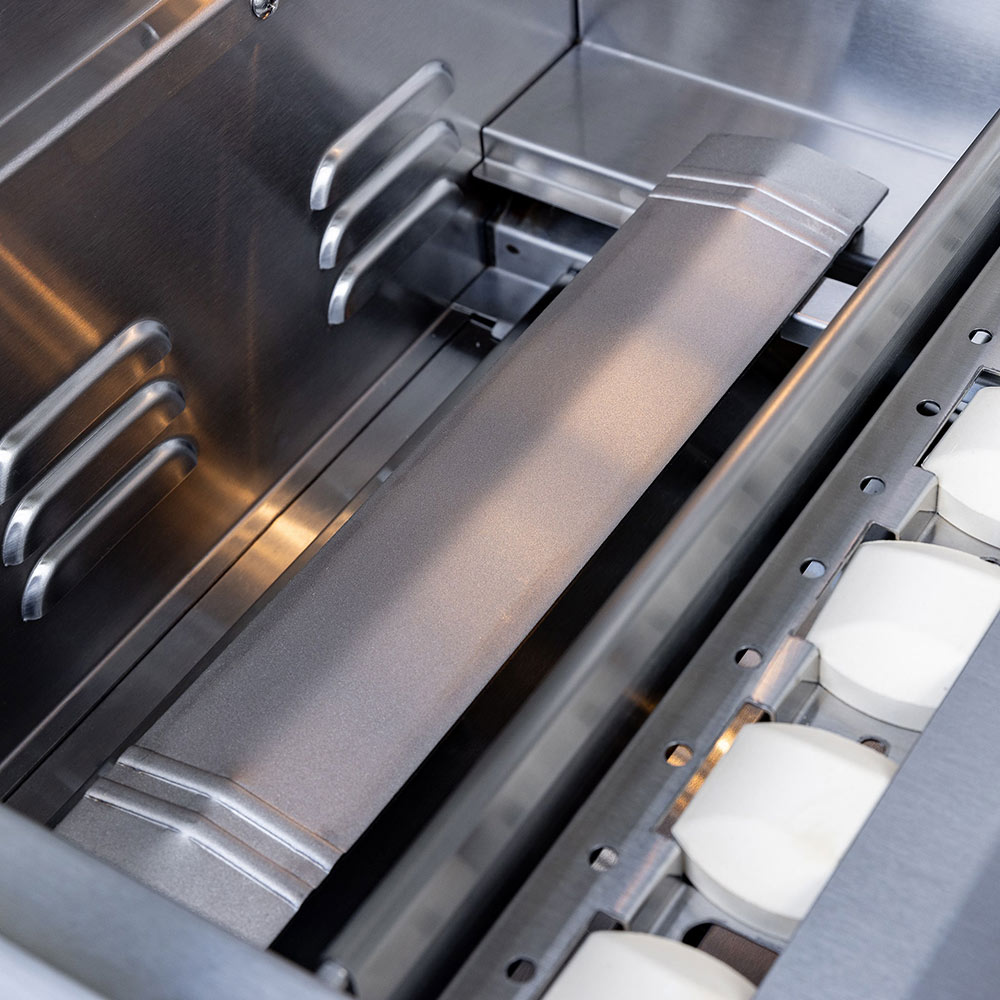 Built-in gas grill interior with stainless steel burners, grates, and metal heat shield