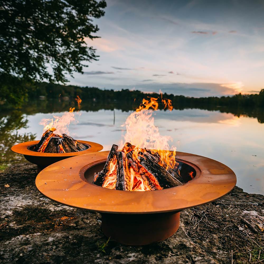 Round gas fire pit with flames burning in the center burner