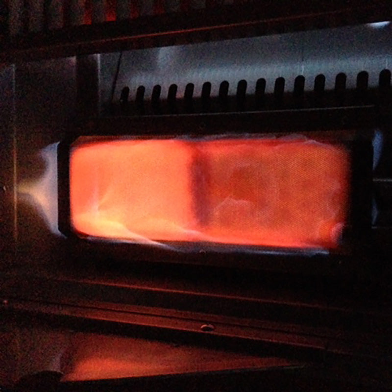 Lit stainless steel sear burner with visible orange flame