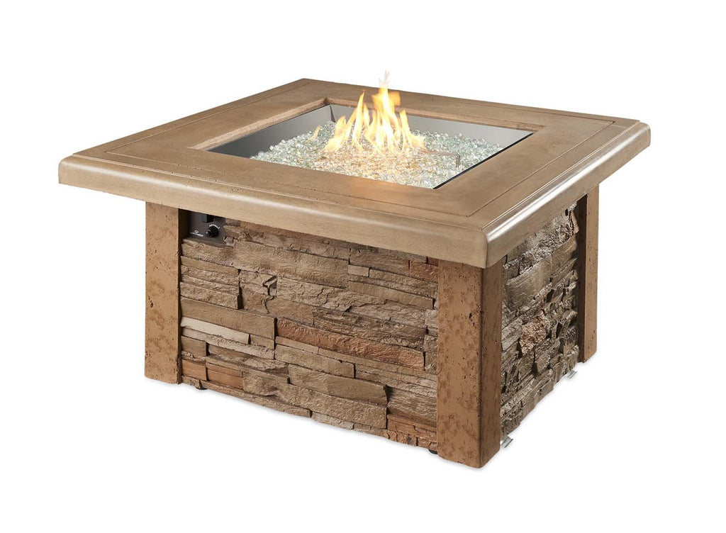 Square gas fire table with stone base and tan top, showing flames and fire media