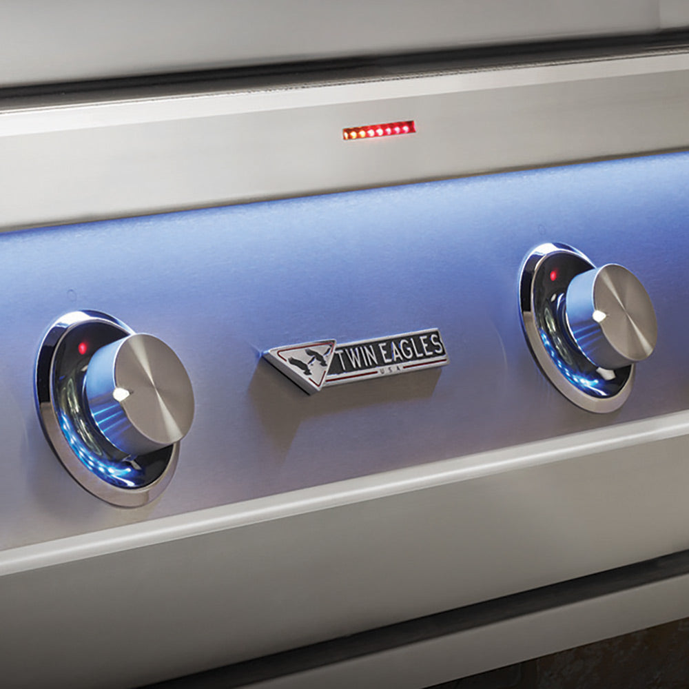 Gas grill control panel with chrome knobs and Twin Eagles emblem on blue fascia