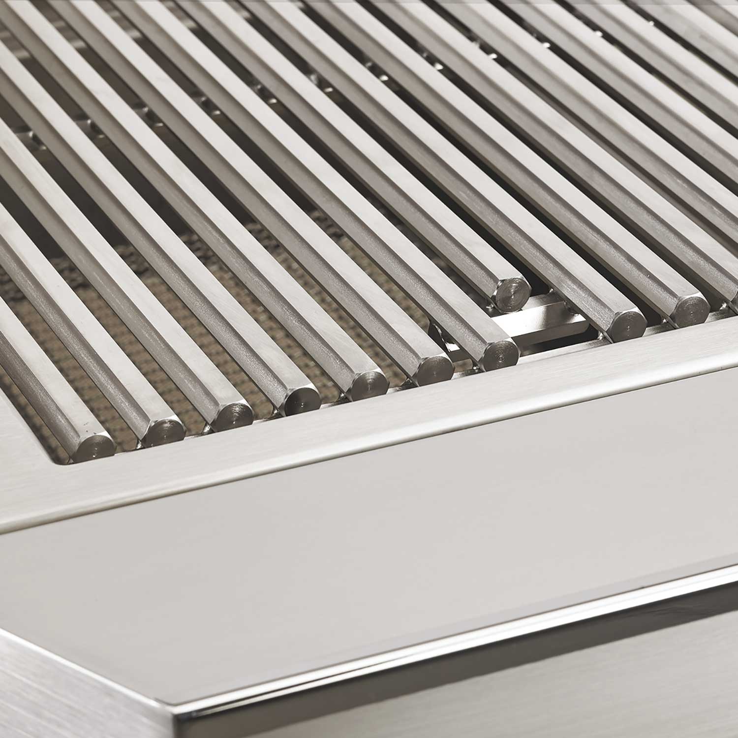 Stainless grill burners beneath metal heat deflector bars