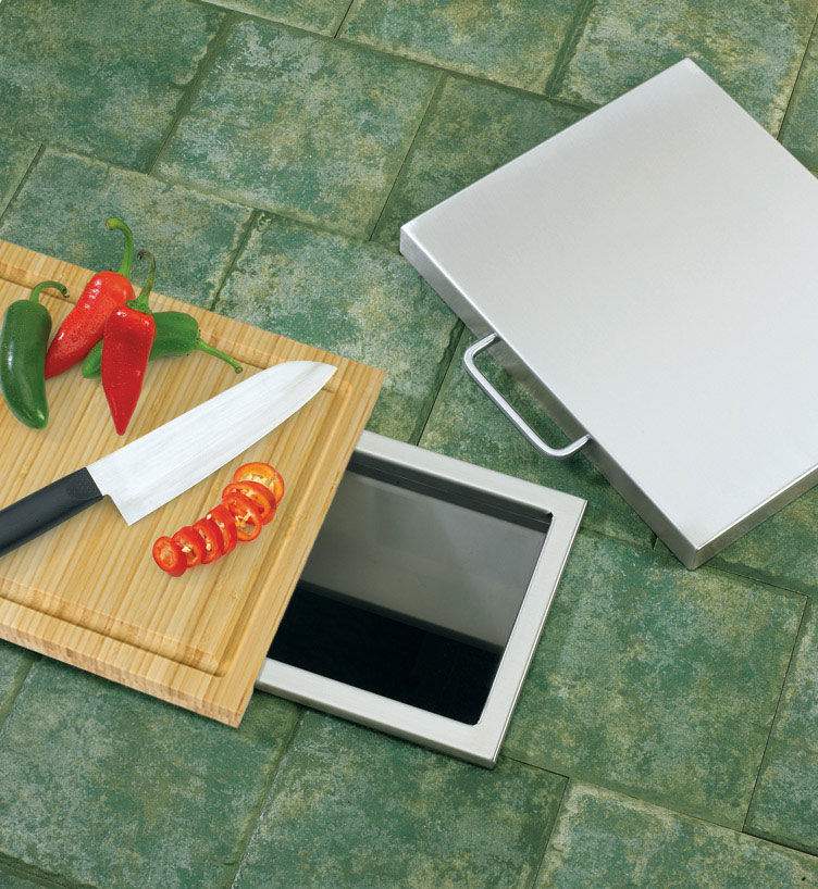Bamboo cutting board with hinged trash chute lid, shown open on the patio