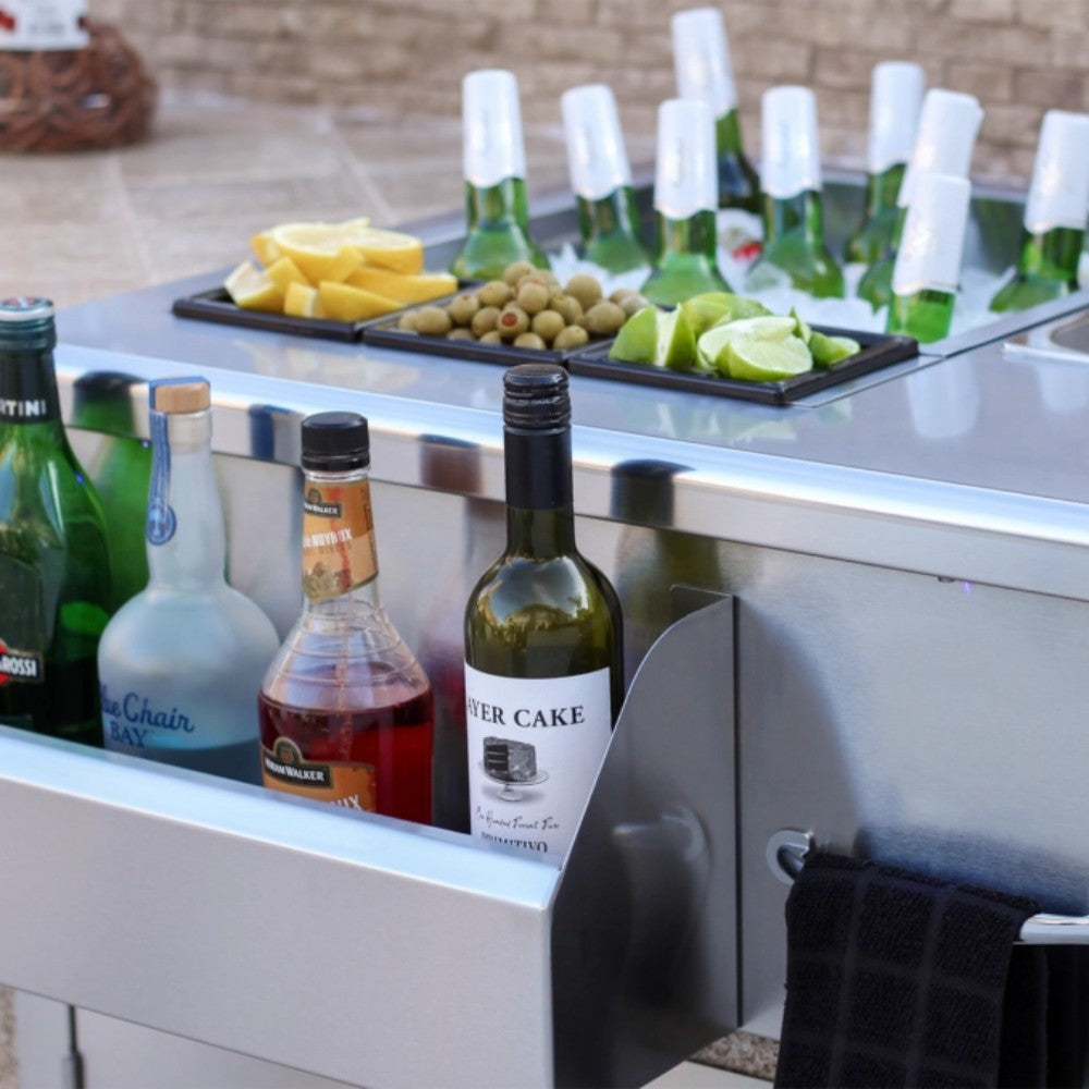 Stainless built-in beverage station drawer filled with bottles and condiments