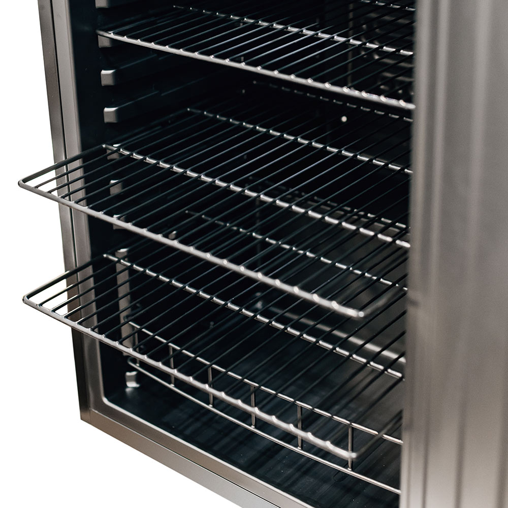 Lower wire rack inside outdoor mini fridge with metal rails and black interior.