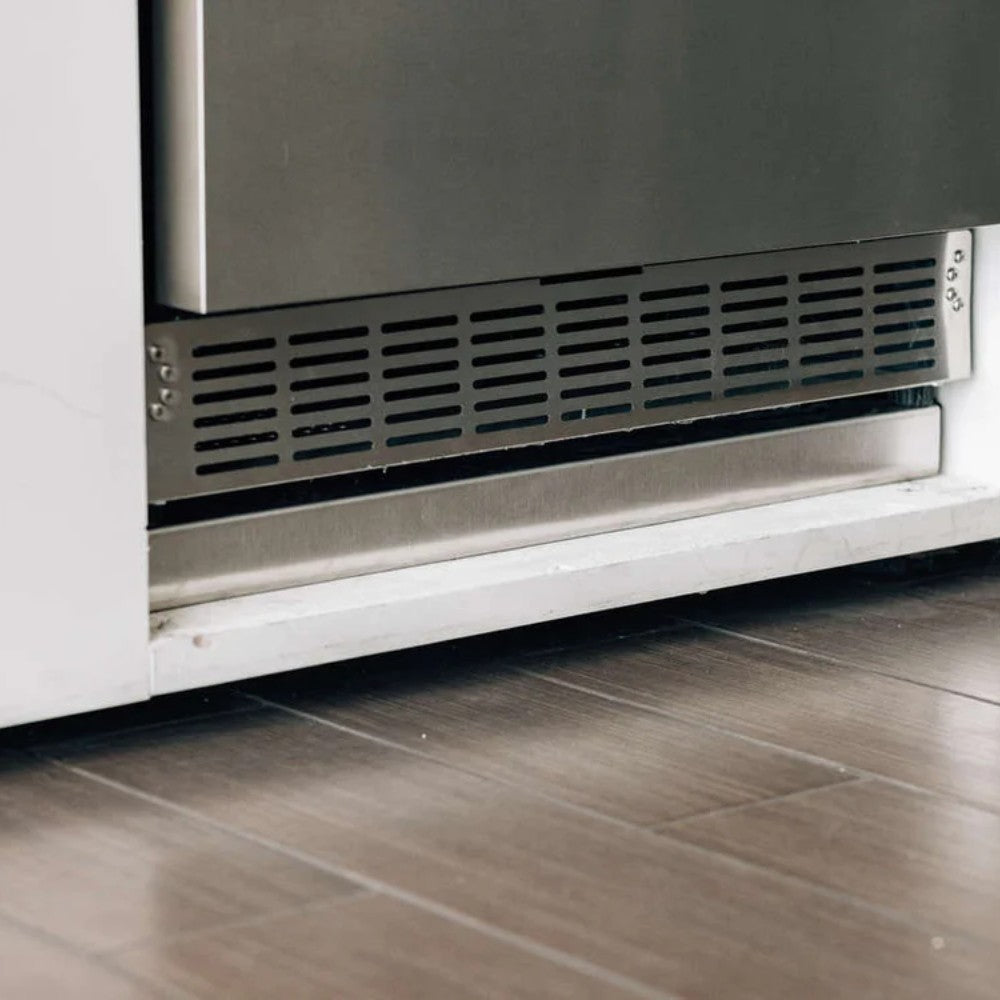 Vented lower grille on a white pedestal base under an outdoor refrigerator