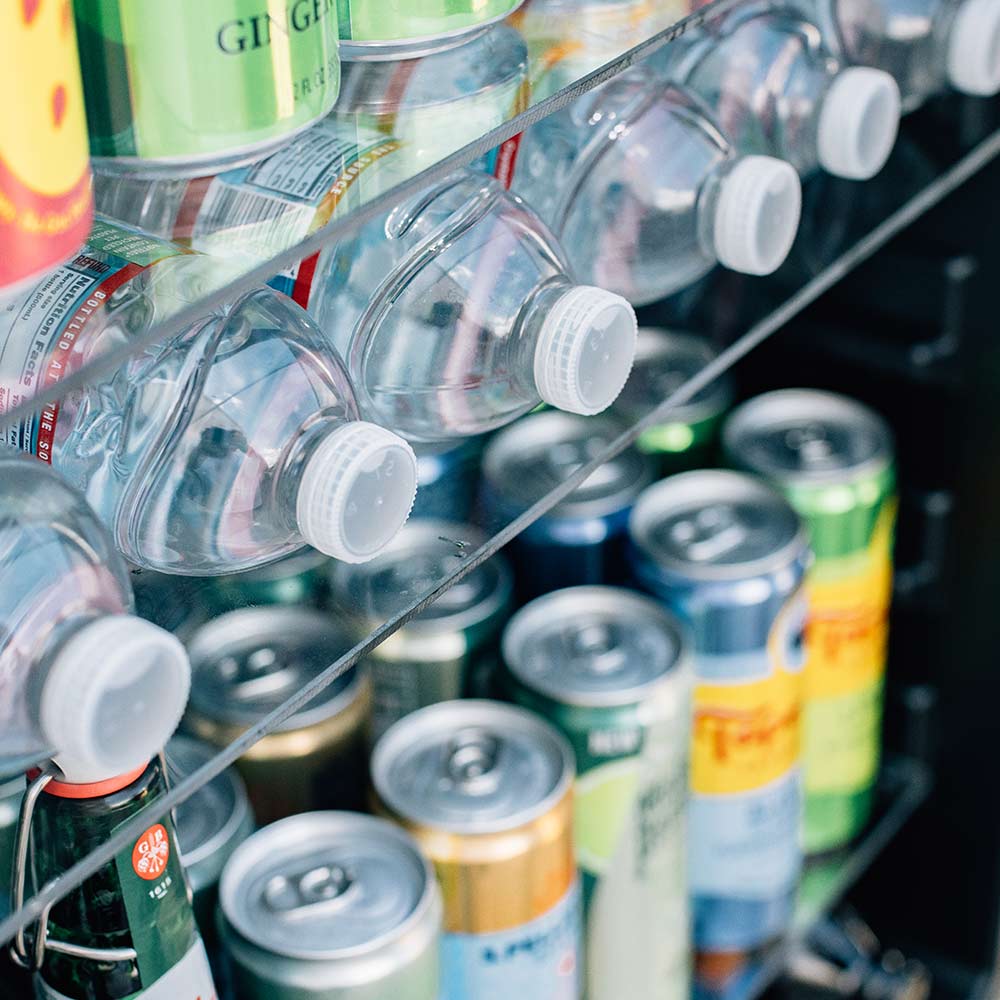 Fridge interior shelf with glass bottles and can beverages on racks