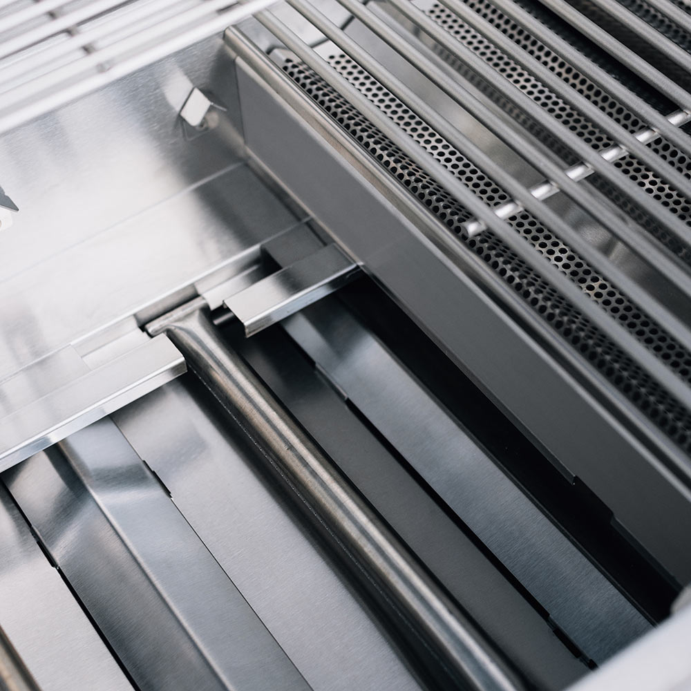 Built-in gas grill interior with metal heat tubes and burner shields