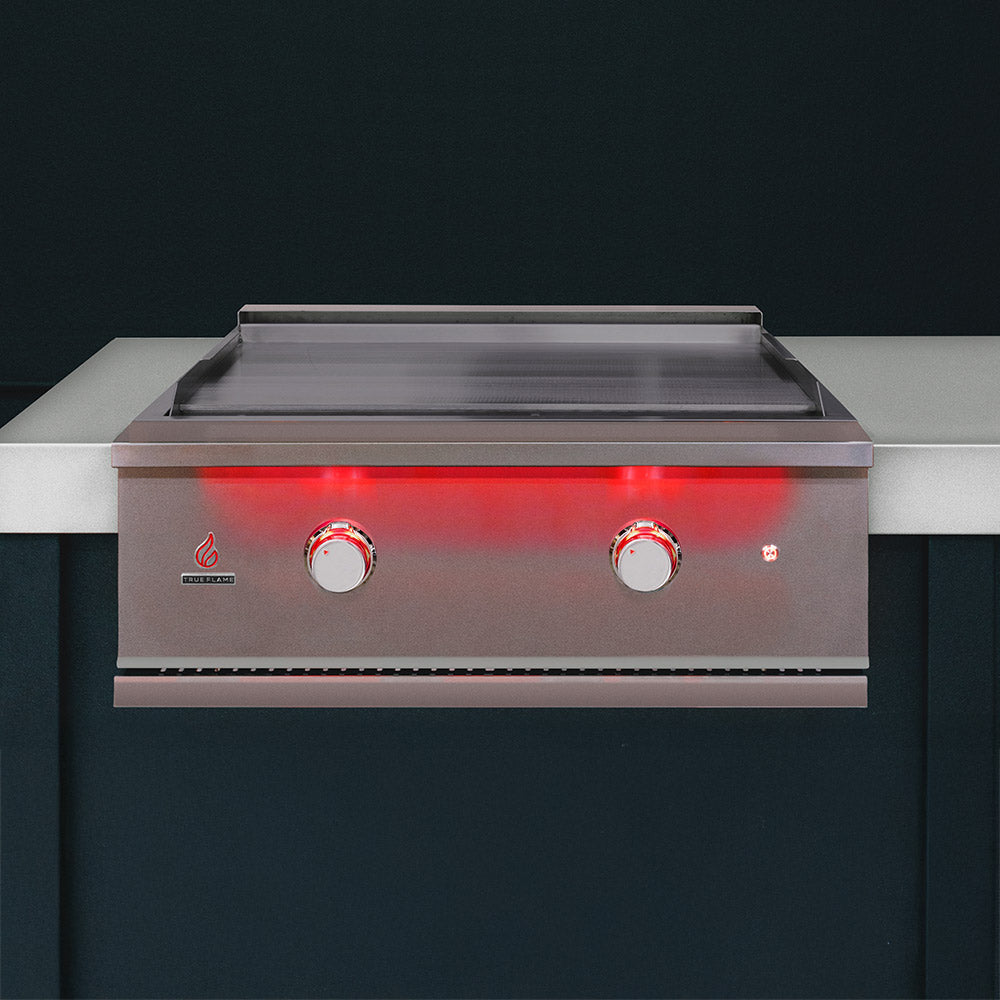 Stainless steel built-in gas griddle installed in countertop with open griddle and two knobs