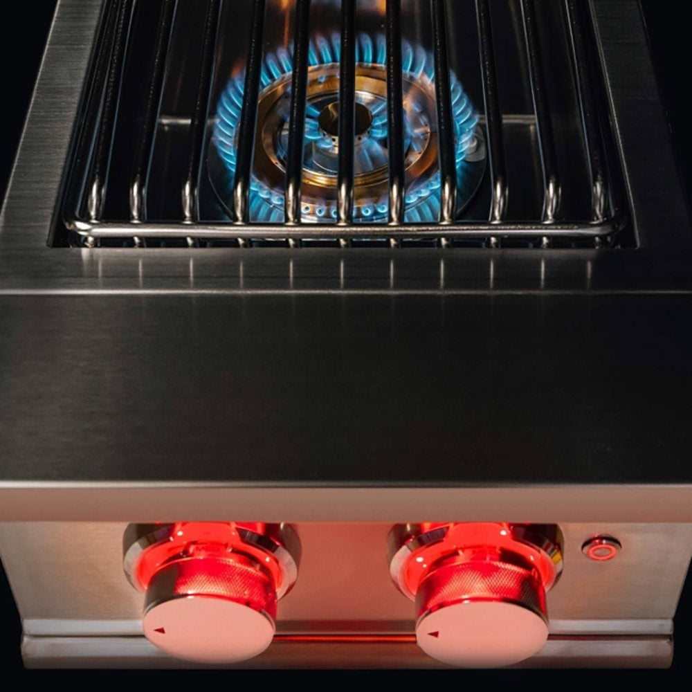 Built-in side burner with open grate, blue flames, and two red control knobs