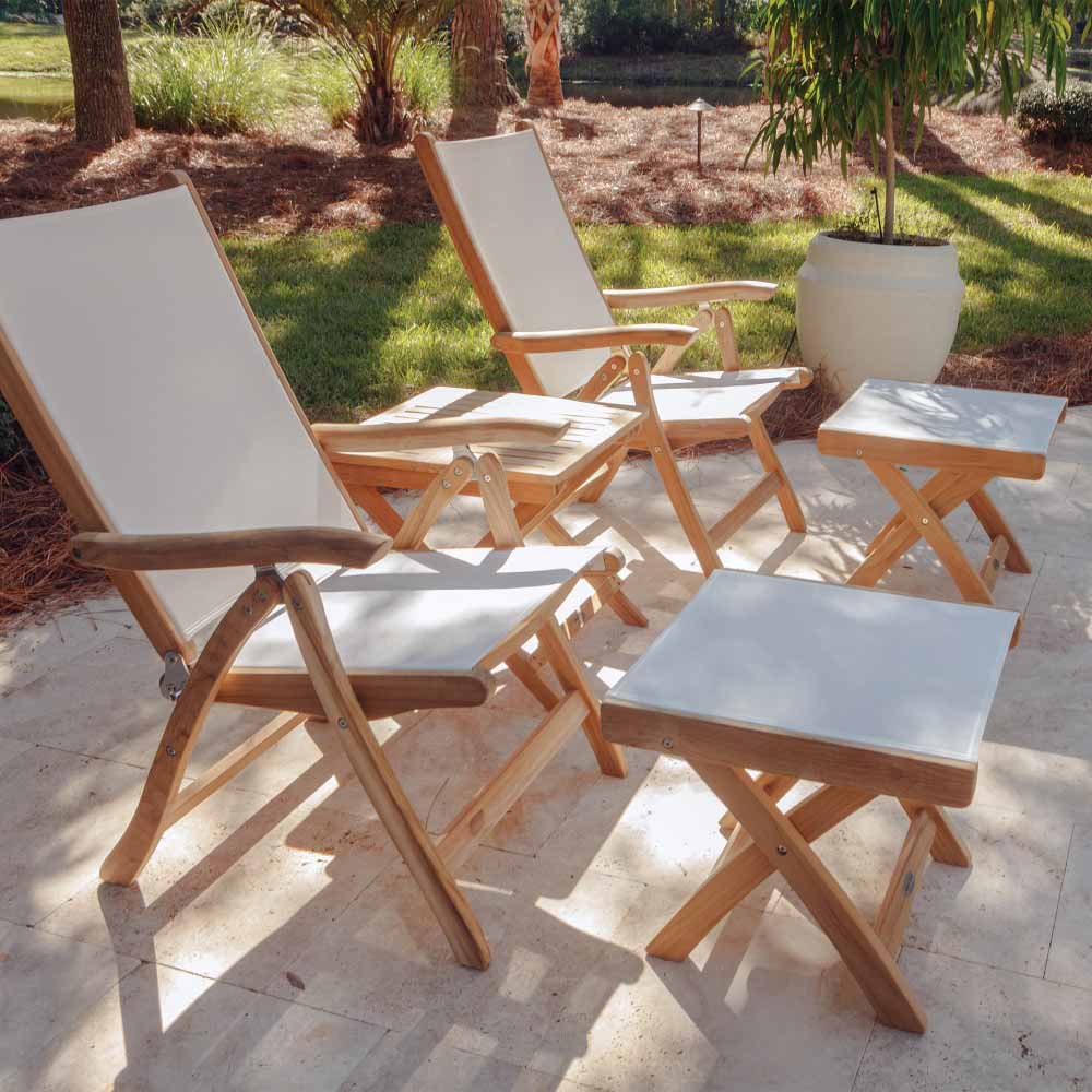 Teak outdoor footrest with light fabric cushion among patio seating