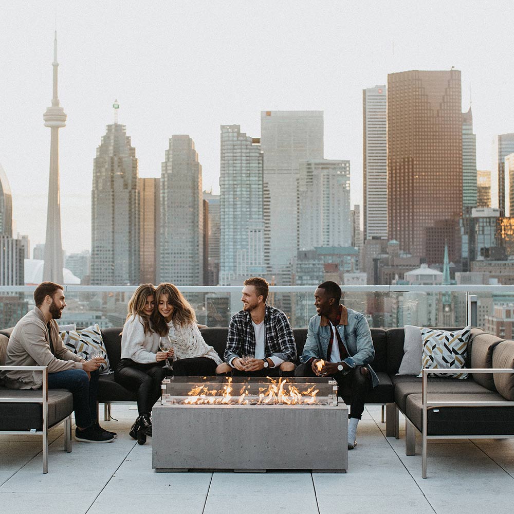 Concrete gas fire pit with burning flames, rectangular tabletop-style design