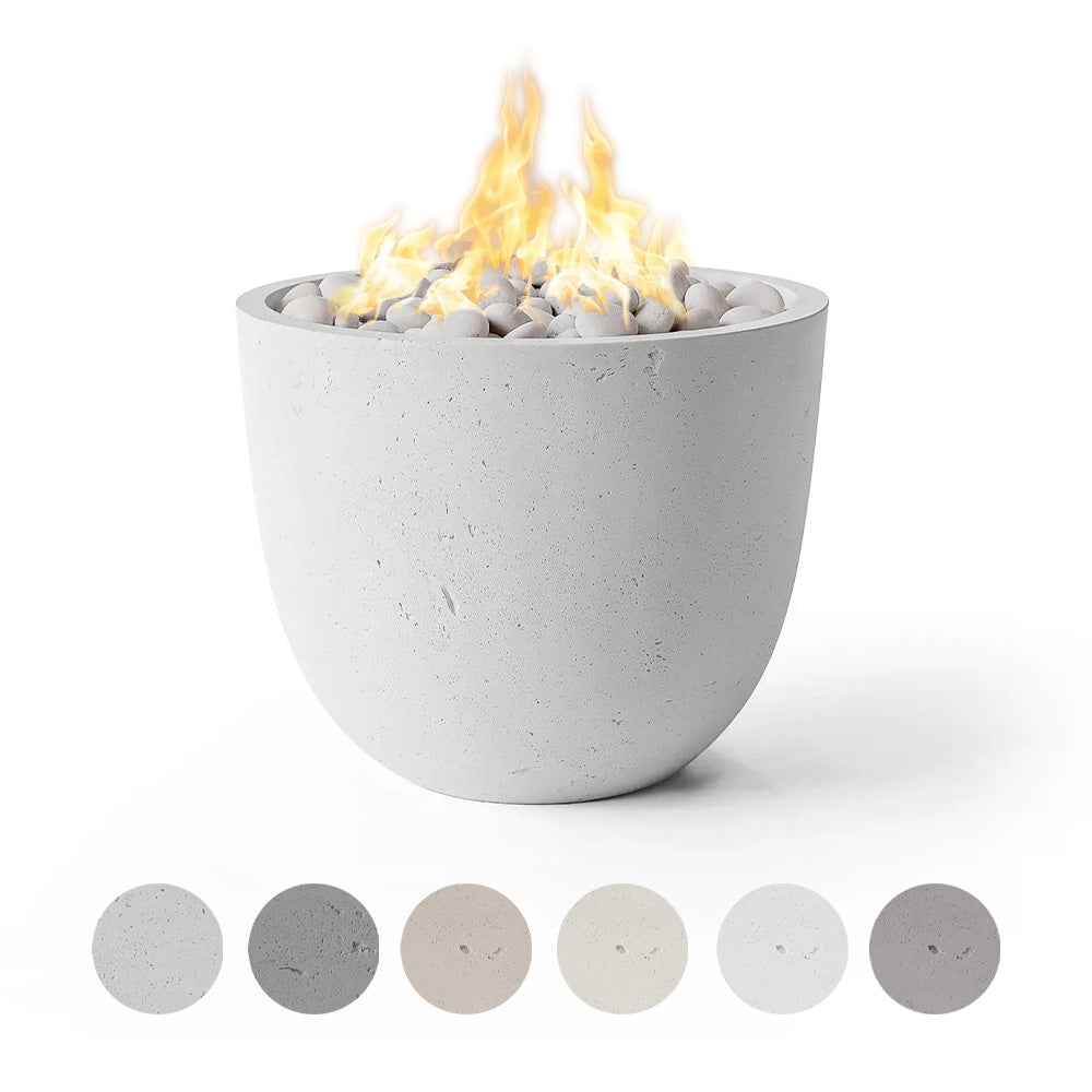 Concrete gas fire bowl with active flames and light gray pebble media