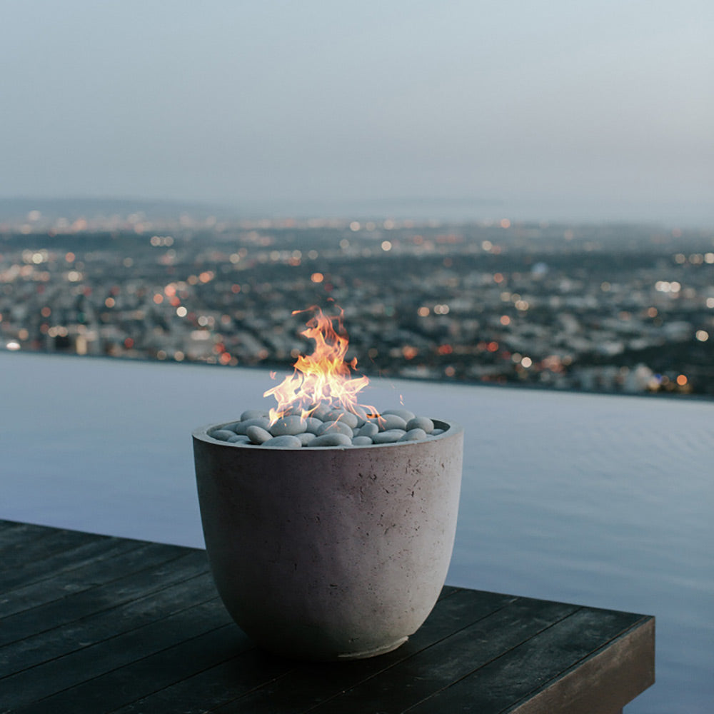 Concrete gas fire bowl with flames and light gray pebble media
