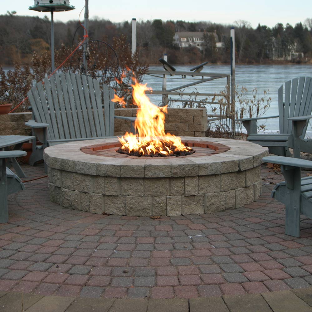 Round stone fire pit with flames burning in the center