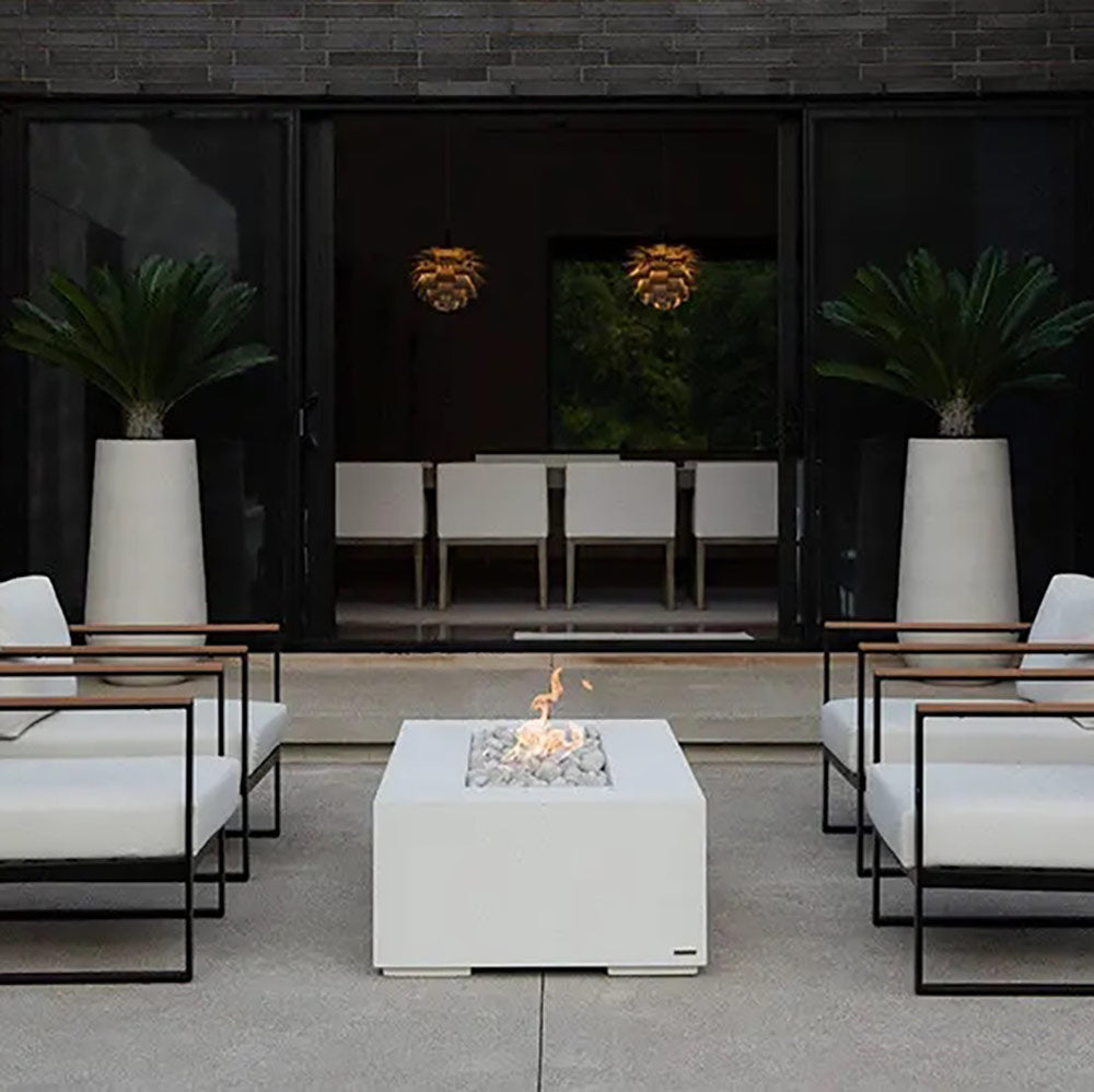 Lightweight concrete gas fire pit with burning flames in a pebble-filled center