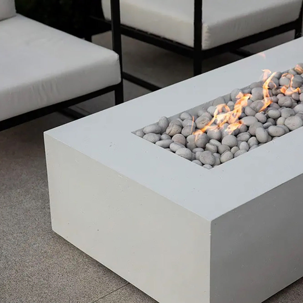 Lightweight concrete gas fire pit close-up with gray pebble stones and small flames