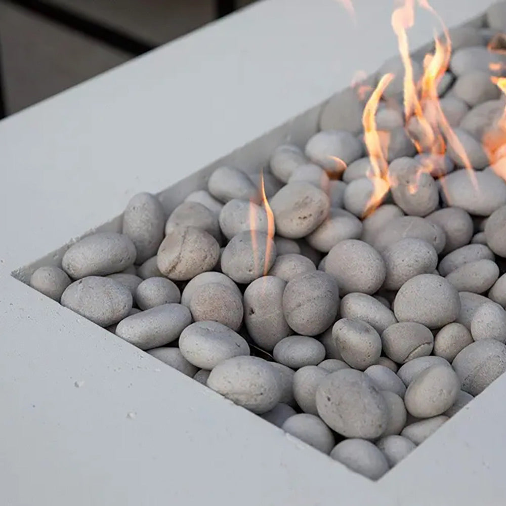 Lightweight concrete gas fire pit close-up of gray pebble stones with flames