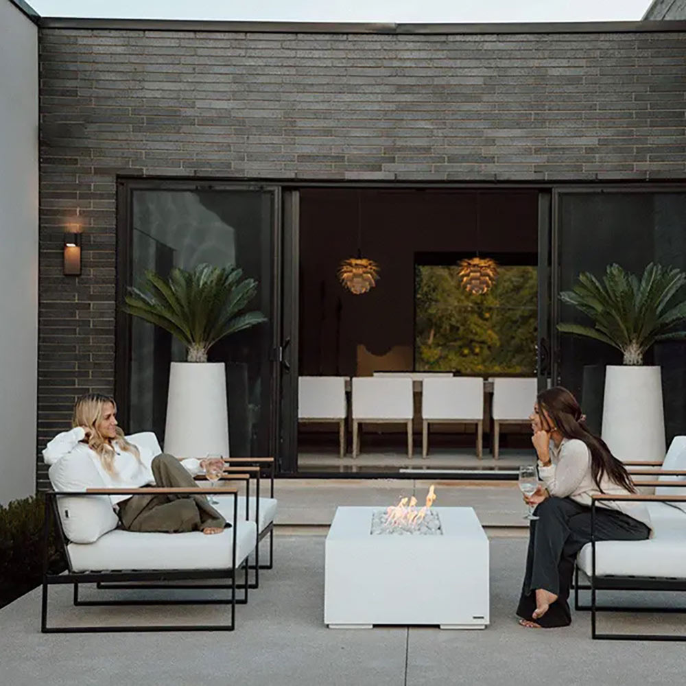 Lightweight concrete gas fire pit on outdoor patio with flames at center
