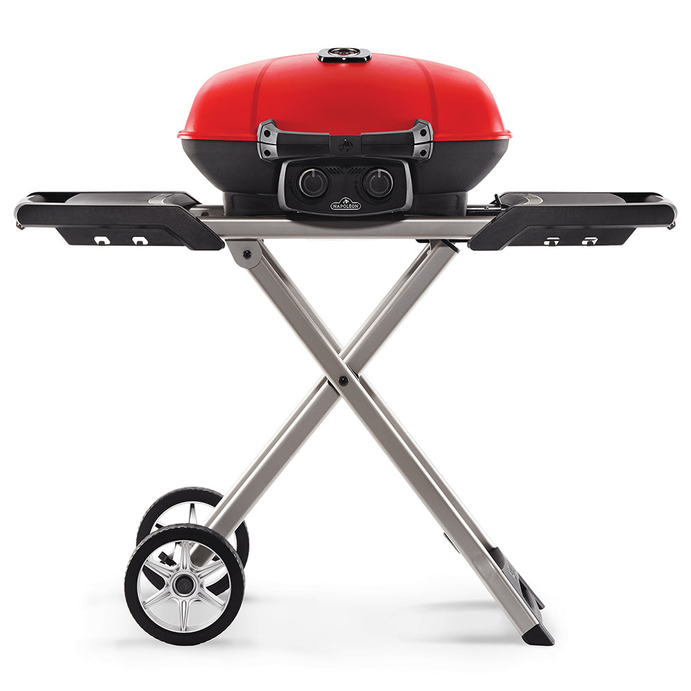 Red portable propane grill with black control panel and side shelves on folding cart.