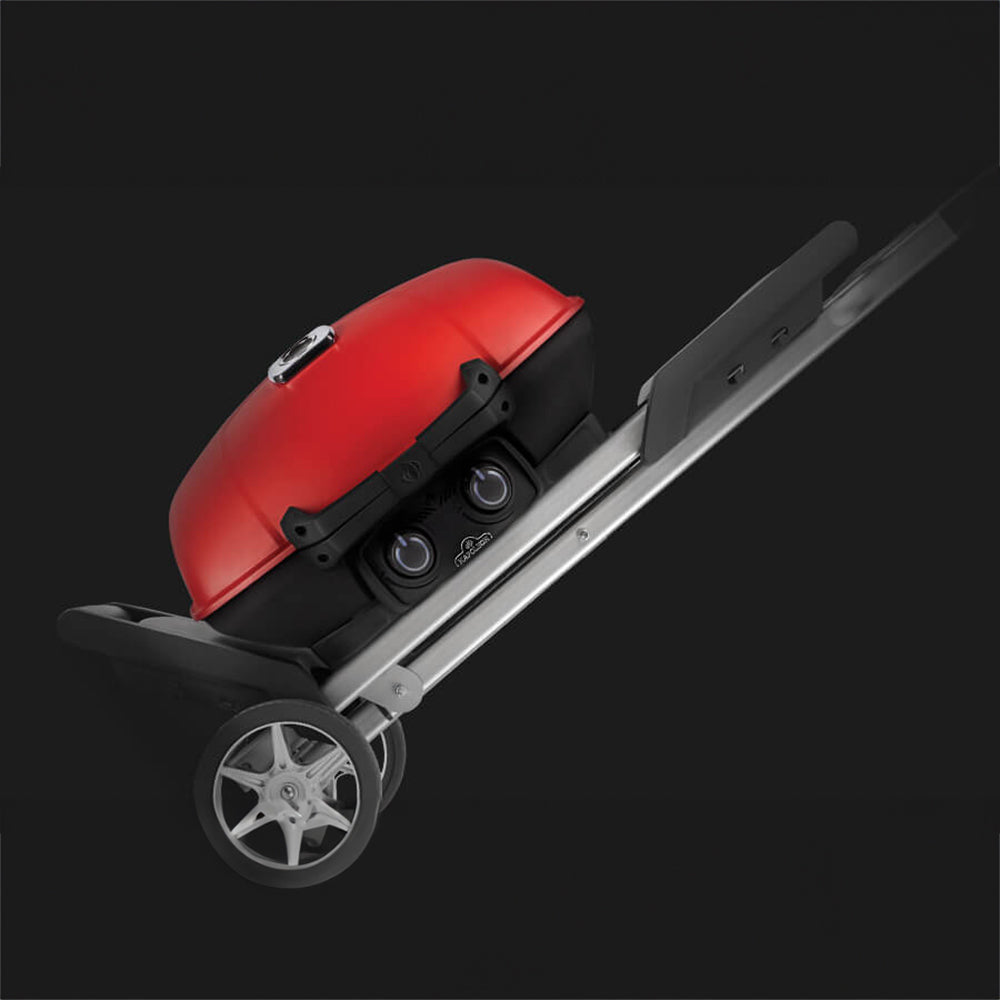 Red grill lid with black lid handle and control knobs on a portable cart.