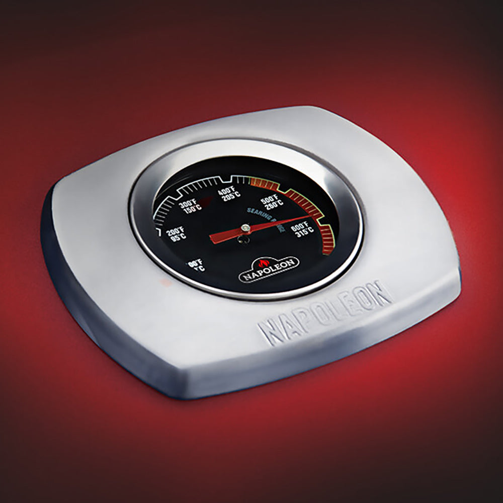 Temperature gauge on a Napoleon-branded grill lid with dial markings.