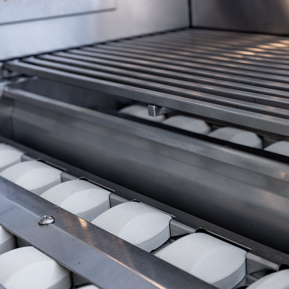 Stainless steel burner tubes under grill grate, close-up