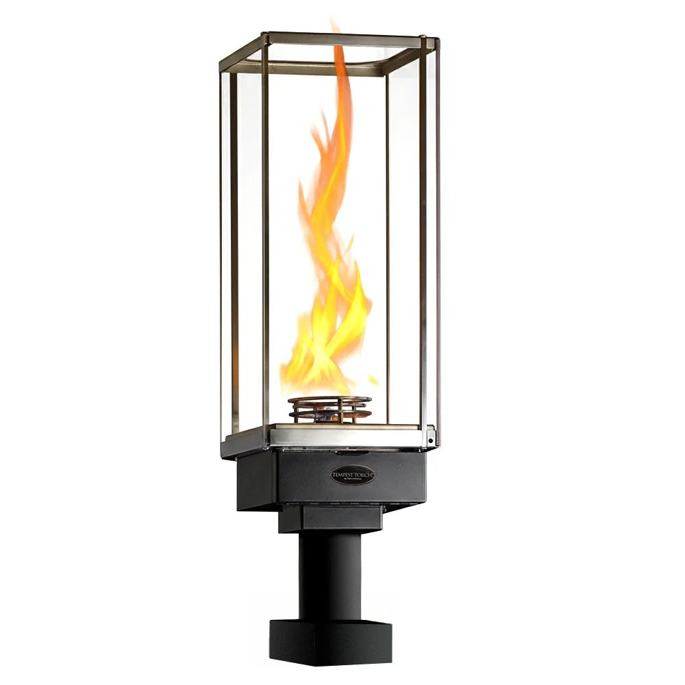 Outdoor gas torch with clear glass enclosure and burning flame on pillar mount
