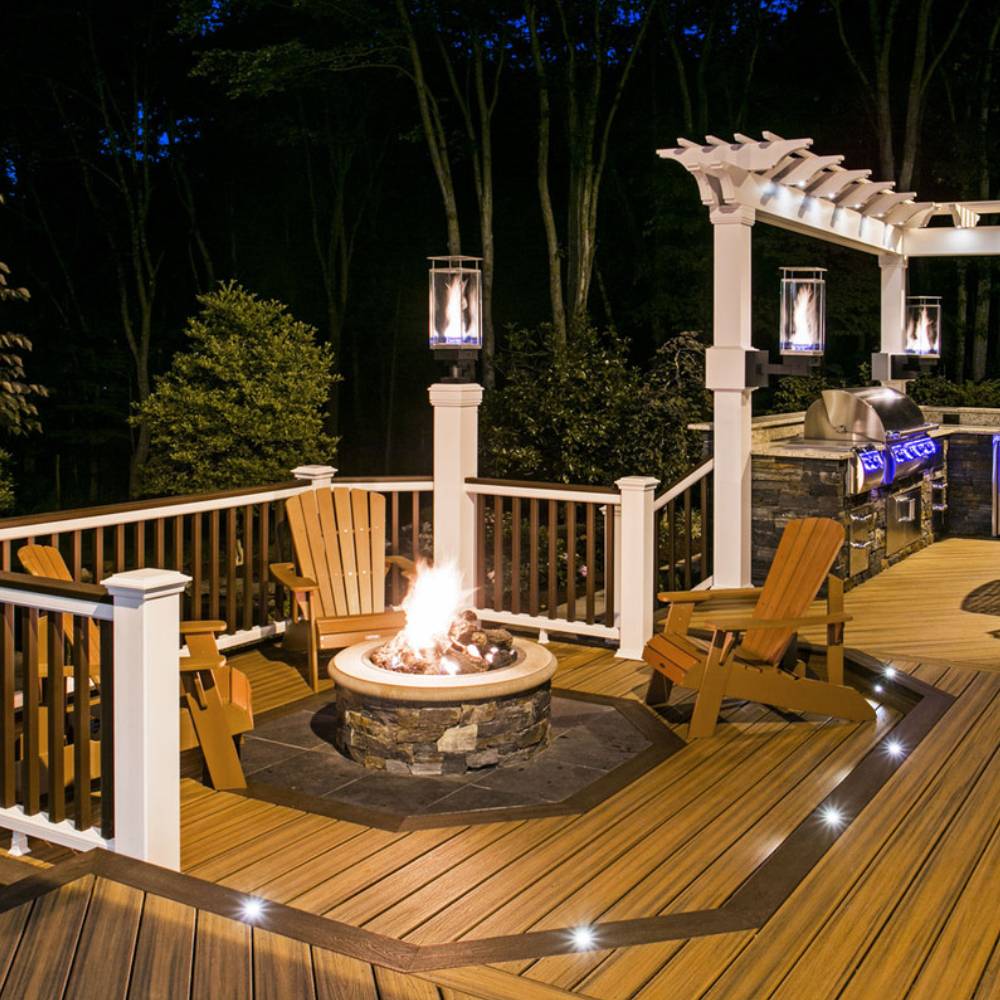 Standing outdoor gas torch with flame inside glass enclosure on wooden deck