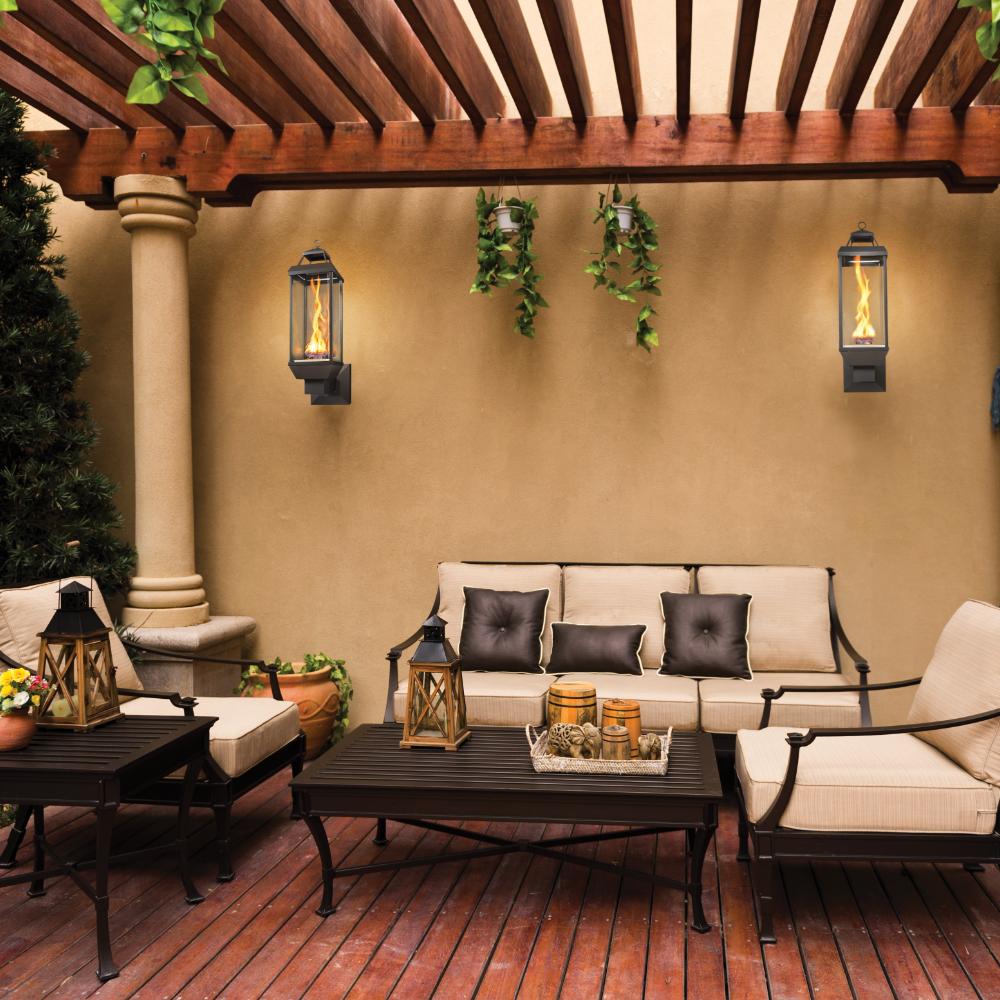 Outdoor wall-mounted gas lantern with glass enclosure and burning flame