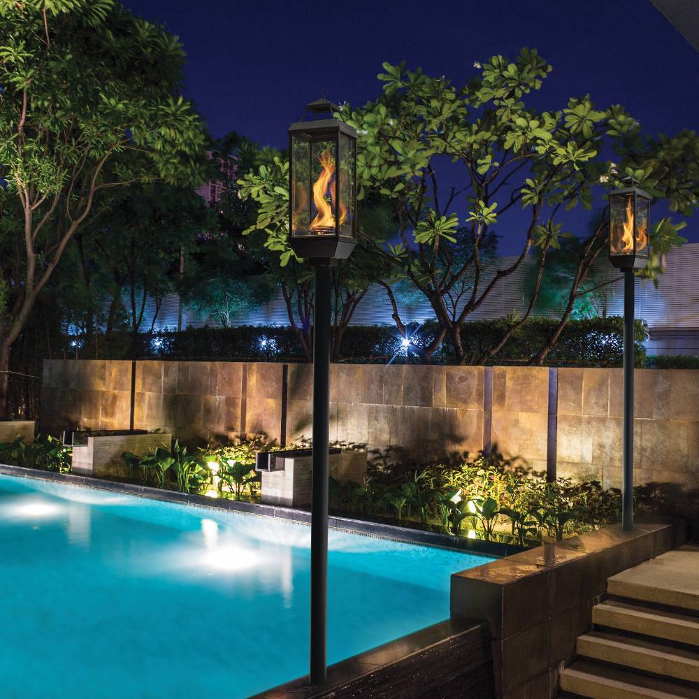 Outdoor gas lanterns with glowing flames on tall dark posts