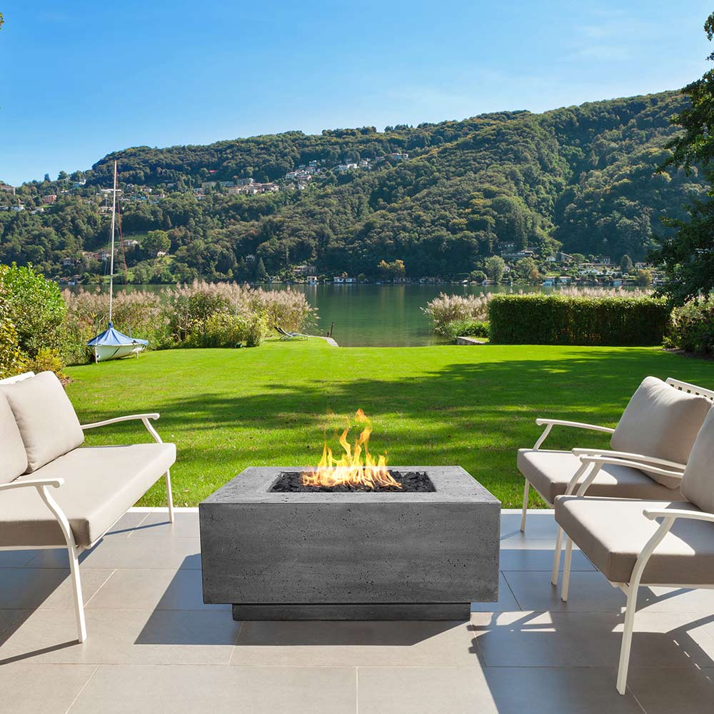 Square concrete gas fire pit with open burner, flames visible in the recessed center