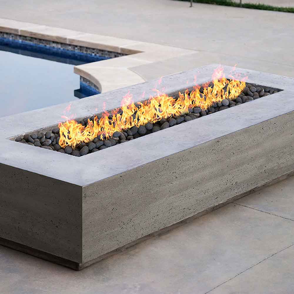Light concrete gas fire pit with flames over dark lava rocks