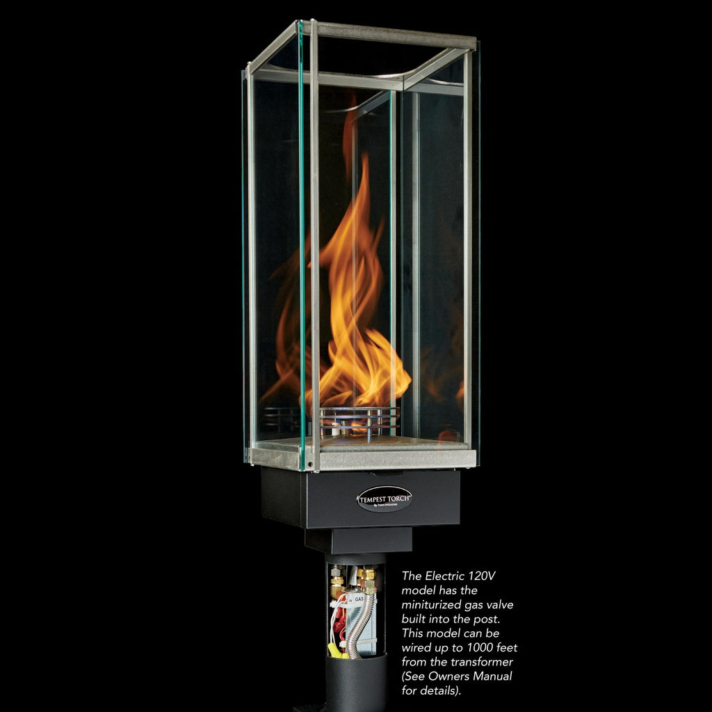 Outdoor gas torch head with clear glass enclosure and flame, dark metal burner housing